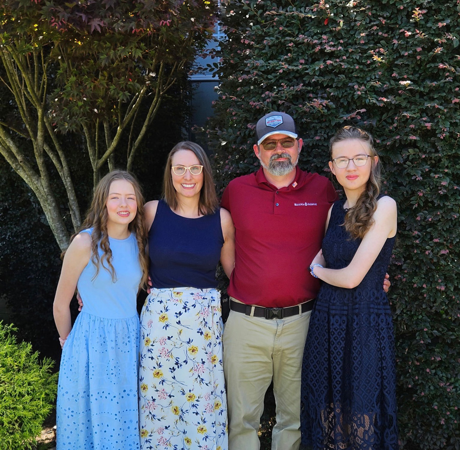 A family photo in the backyard with Dad, Mom, and two daughters