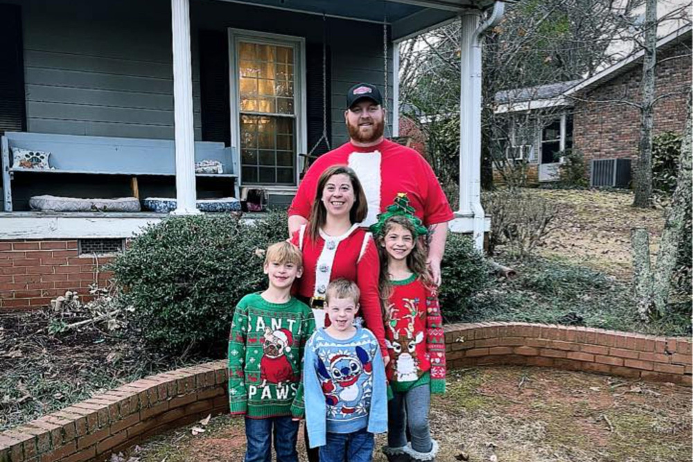 Family photo outside dressed in Christmas sweaters.
